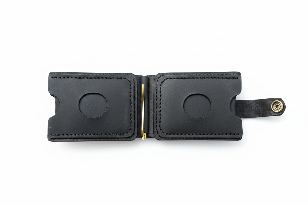 Black leather wallet open showing dual card slots with thumb cutouts, gold money clip and snap closure on white background