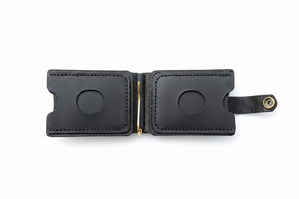 Black leather wallet open showing dual card slots with thumb cutouts, gold money clip and snap closure on white background