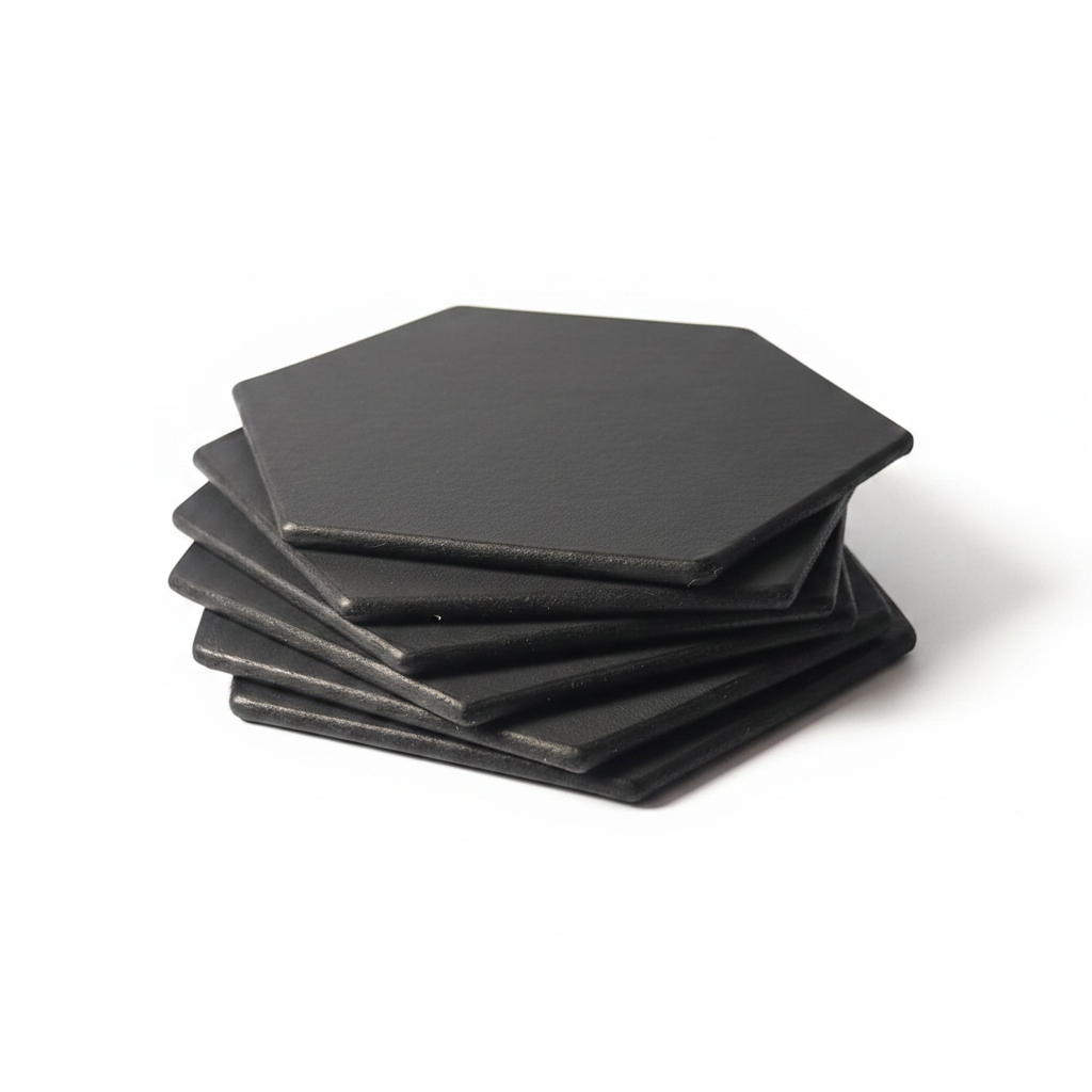 Stack of black hexagonal leather coasters on white background
